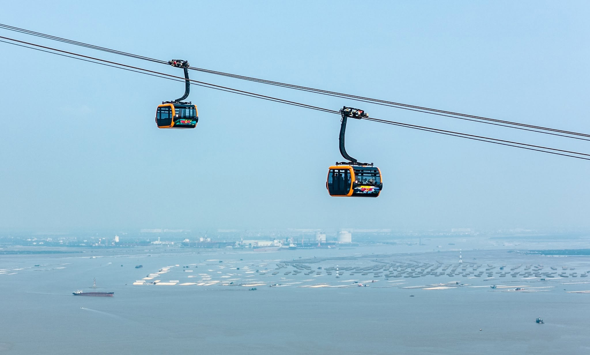 Cabin cáp treo lướt qua những hòn đảo đá vôi giữa làn nước xanh ngọc của vịnh Lan Hạ
