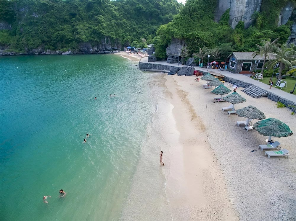 Du khách vui chơi và tắm biển tại bãi Cát Cò với làn nước trong xanh vào ban ngày