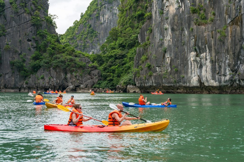 Du khách chèo kayak và ngắm những đảo đá phủ xanh trong hành trình khám phá vịnh Lan Hạ