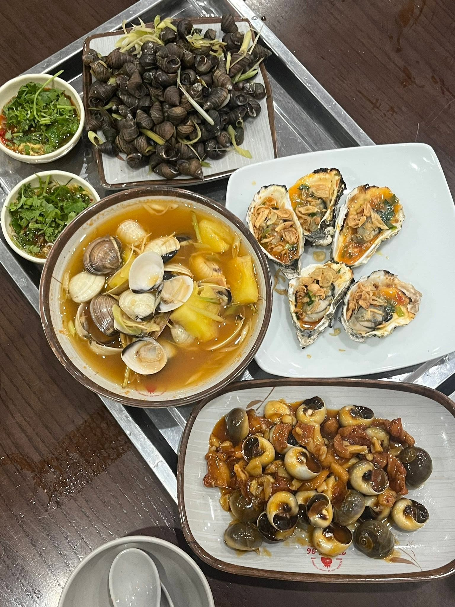 Đĩa ốc nóng phủ nước sốt sánh đậm là lựa chọn hấp dẫn cho buổi tối khám phá ẩm thực Hải Phòng