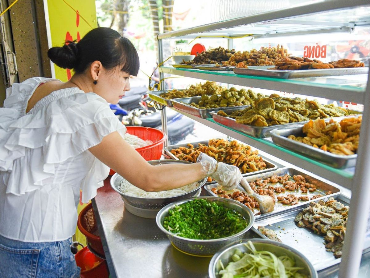 Thưởng thức bún cá cay Hải Phòng đầy đủ topping.