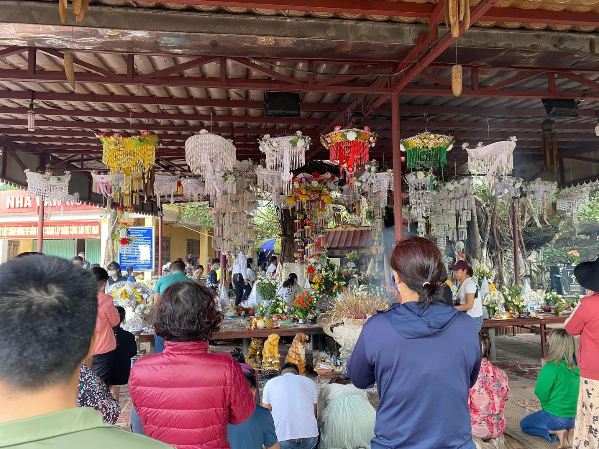 Du khách thức hiện nghi thức khấn vái trước đền thờ gốc cây đa.